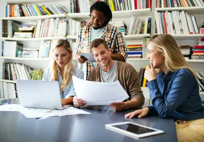Collega's aan bureau met laptop en geprinte documenten