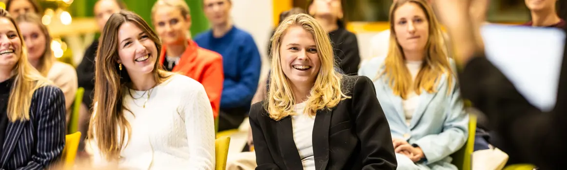 bvA Next event kerscommercial lachende vrouwen die luisteren naar presentatie