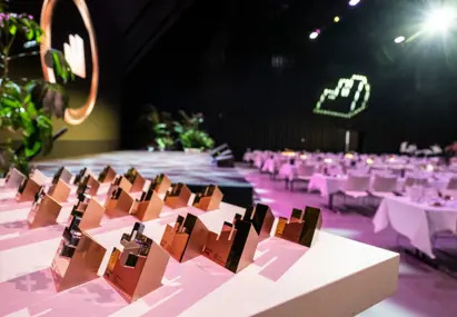 Tafel met alle effie awards erop gezet en op de achtergrond lege gedekte tafels