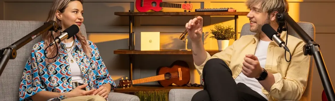 Man en vrouw praten met elkaar in een podcast setting