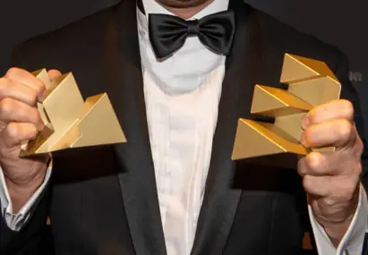 Man in pak met twee Effie Awards in zijn hand 