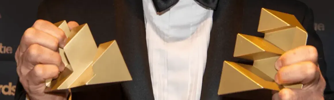 Man in pak met twee Effie Awards in zijn hand 