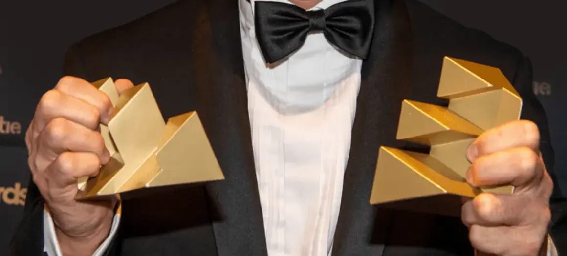 Man in pak met twee Effie Awards in zijn hand 