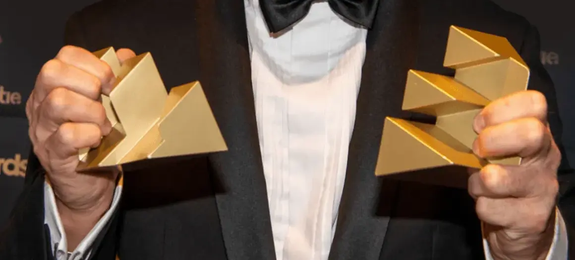 Man in pak met twee Effie Awards in zijn hand