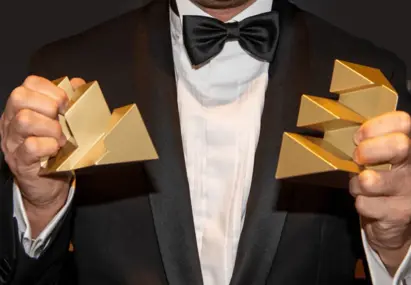 Man in pak met twee Effie Awards in zijn hand
