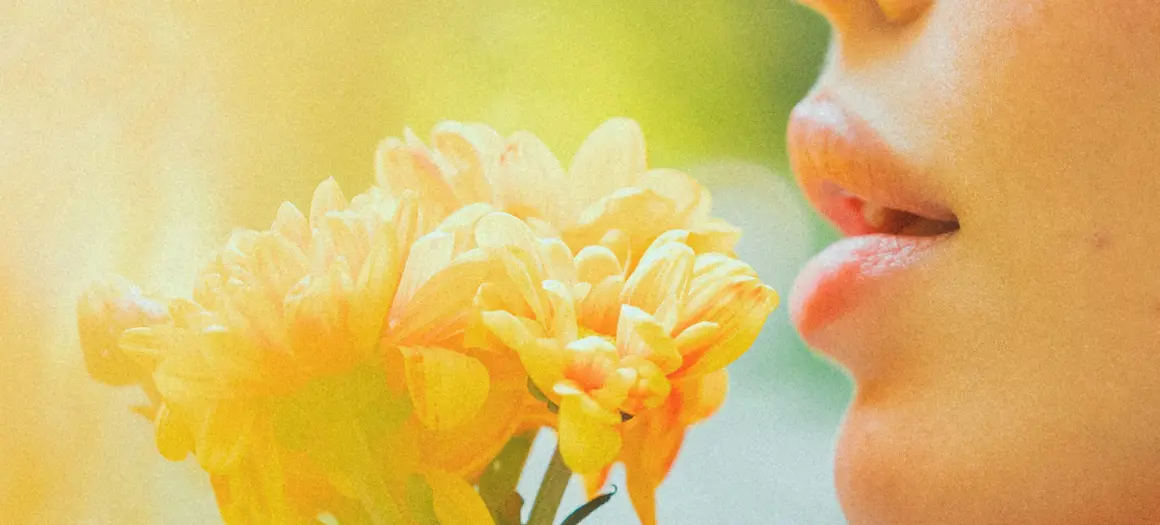 Vrouw ruikt aan gele bloemen