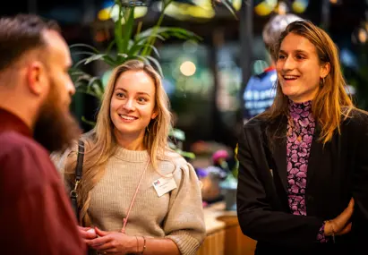 Aanwezigen vrolijk in gesprek met elkaar tijdens borrel bvA Next event de kerstcommercial ontrafeld