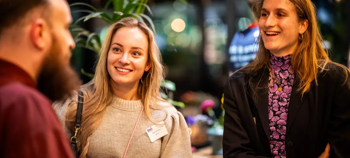 Aanwezigen vrolijk in gesprek met elkaar tijdens borrel bvA Next event de kerstcommercial ontrafeld