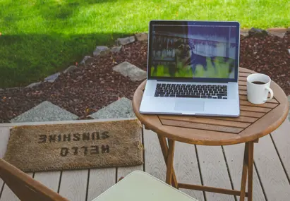 Tafel buiten met laptop en gras op de achtergrond