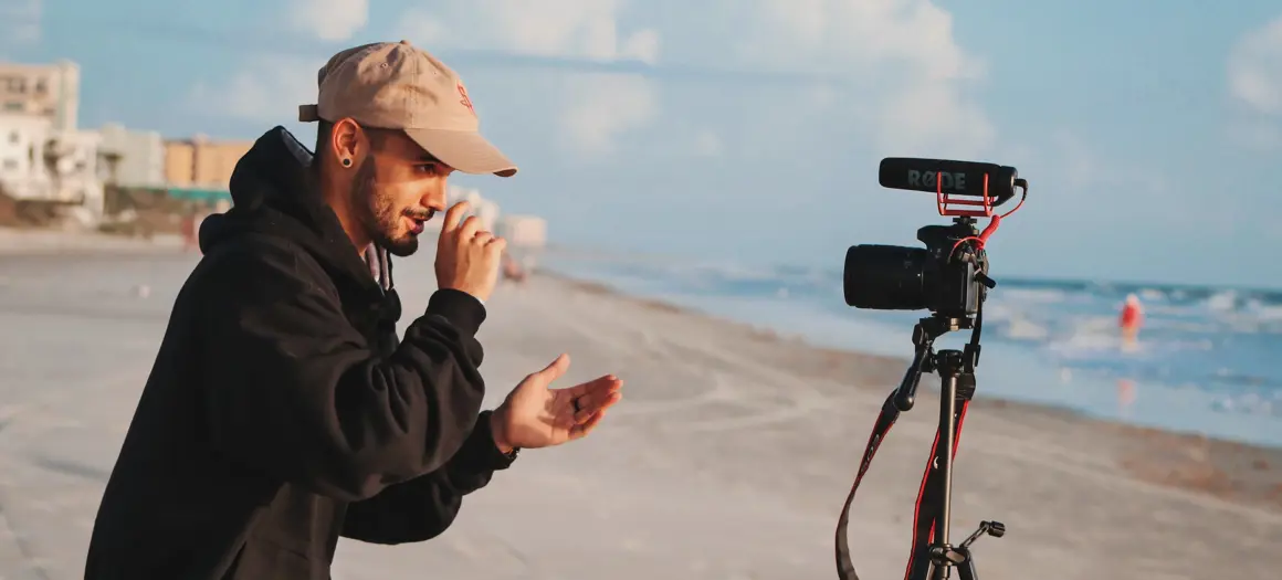 Jongen filmt zichzelf met camera op strand