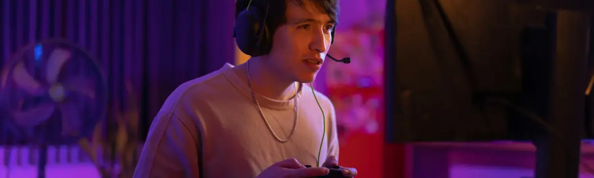 Man met handset en joystick in hand achter computer