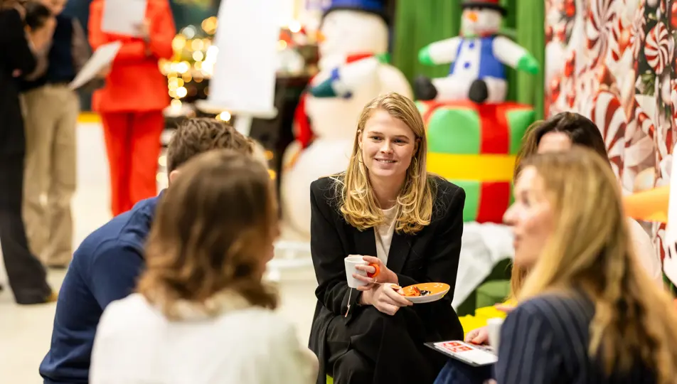 bvA Next event kerscommercial kleine groep in gesprek en sneeuwpop op achtergrond